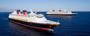 Two Disney Cruise Line ships in dark blue waters