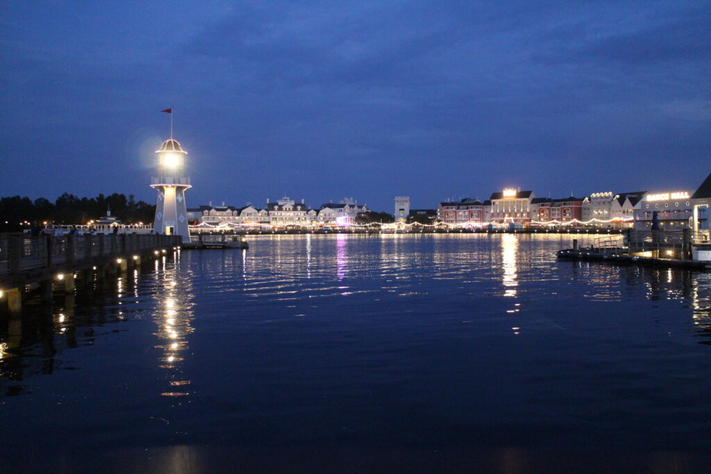 Dark waters of Crescent Lake reflect the lights of the Disney BoardWalk in the distance and the lighthouse that illuminates the area Can I sell my DVC?