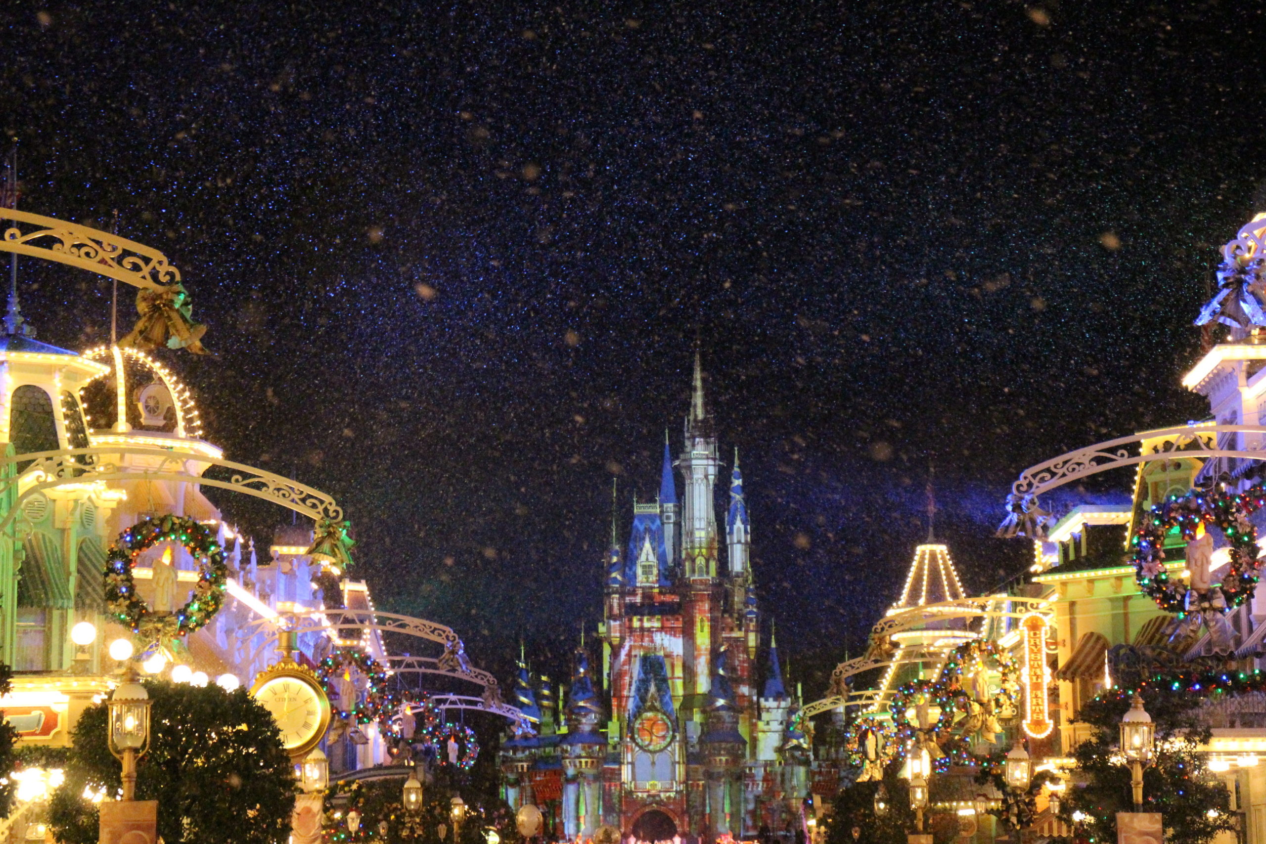 Night time on Main Street USA with snow and Cinderella Castle