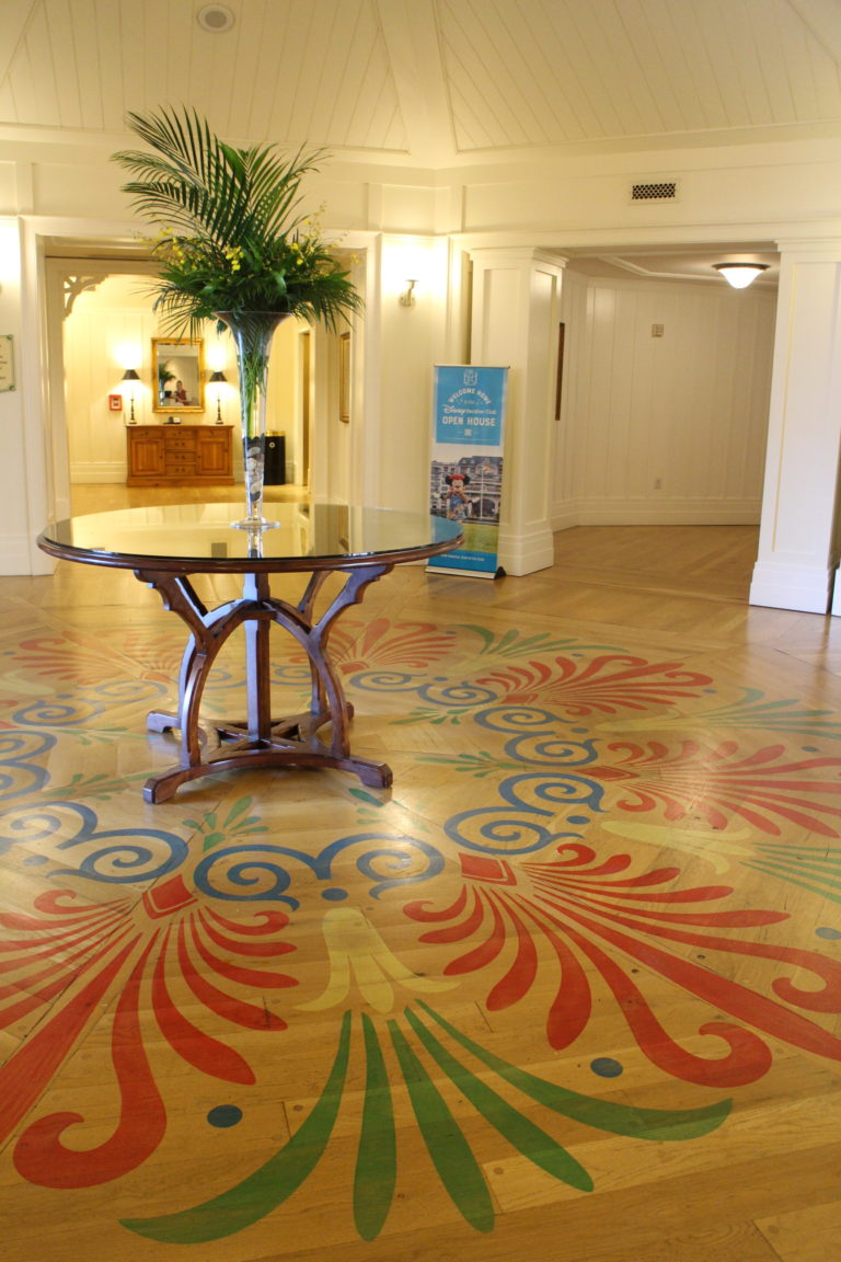 ornate pattern on wood floor under a round table with a plant in the Disney's Beach Club Villas lobby