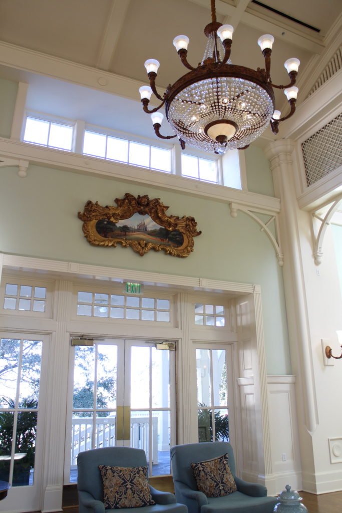 A bejeweled chandelier hangs in the BoardWalk resort lobby in front of a wall with glass doors and windows