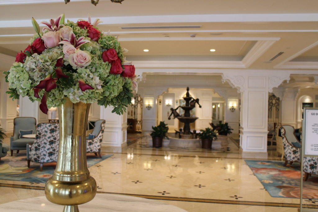 A hydrangea and rose flower arrangement sits in front of white marble floors