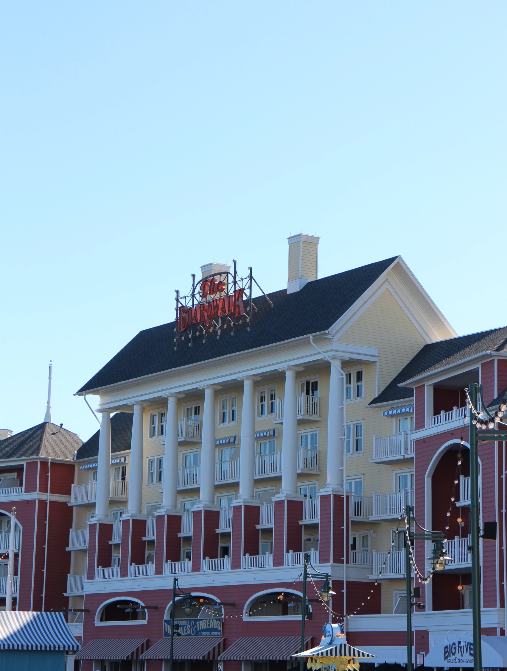 The BoardWalk sign in red lettering on top of a muted yellow and muted red building at the Disney's Vacation Club resort of the same name