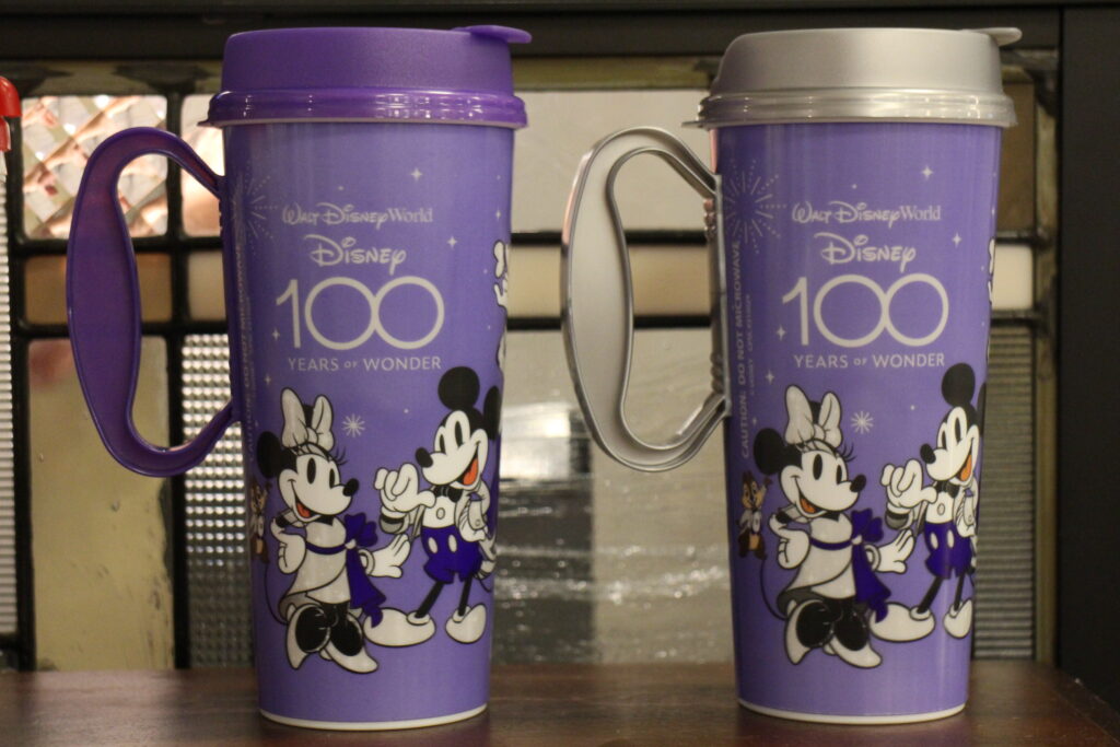 Disney 100 Resort Mugs from Disney World that are purple with silver accents and have Mickey and Minnie in special attire on them