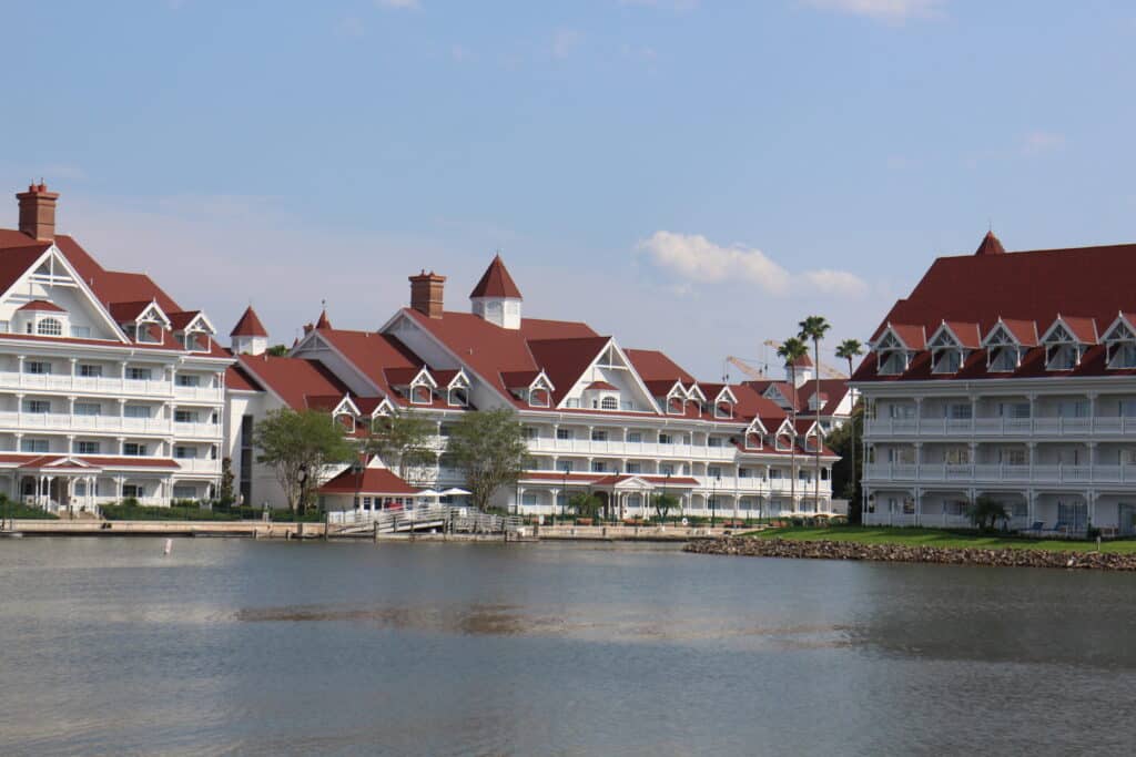 The red roofed, white Grand Floridian buildings surround the marina waters