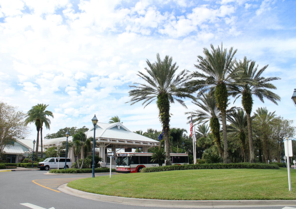 A bus in the porte cochere at Disney's Old Key West Resort with palm trees in front of the resort