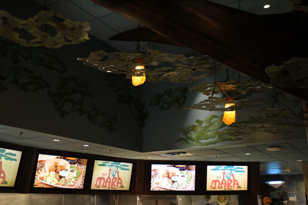 An artsy, tree inspired ceiling, hanging lights and video screen menus at The Mara, the quick service of Animal Kingdom resort restaurants