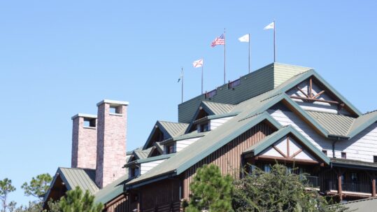 Green roof on the Wilderness Lodge lobby building with chimneys in front of a blue sky