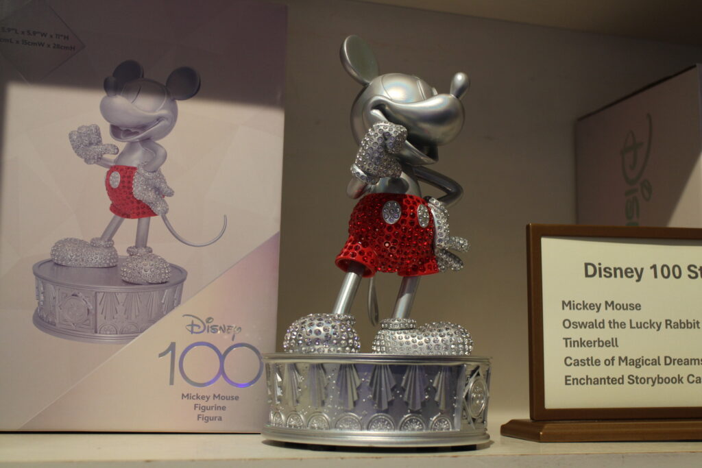 a silver statue of mickey mouse with red shorts and rhinestones