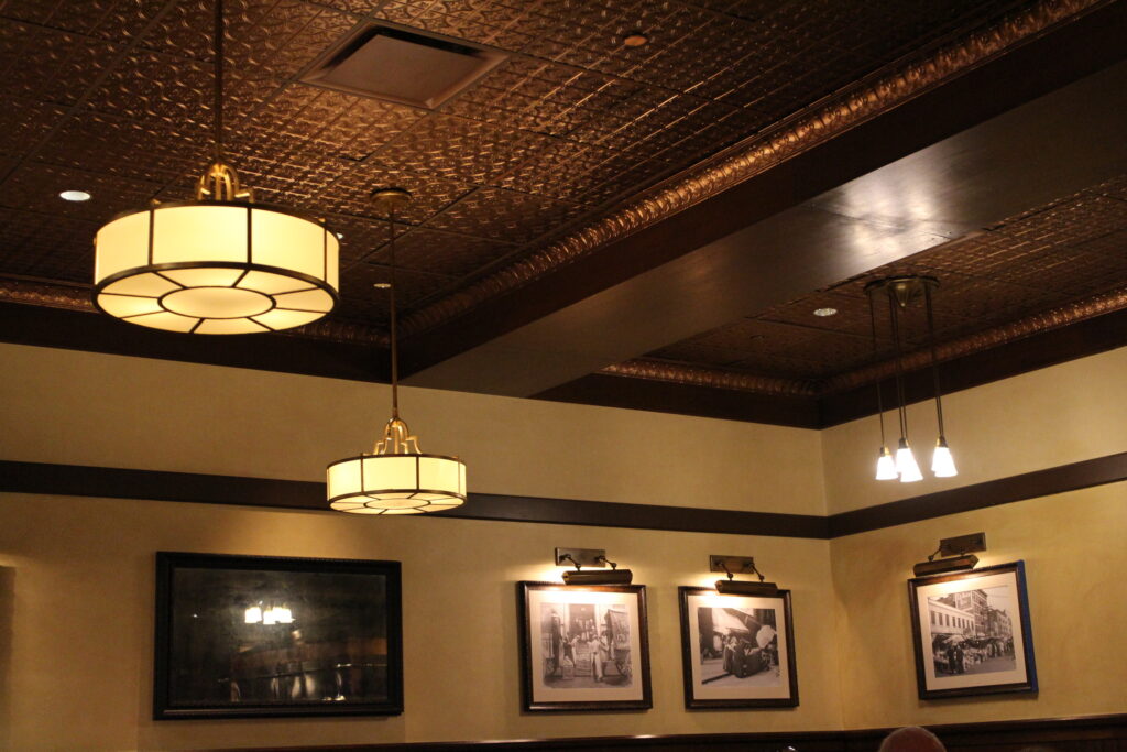 dark ceiling with warm lighting fixtures hanging inside one of the former Disney character meals at resorts Trattoria al Forno restaurant