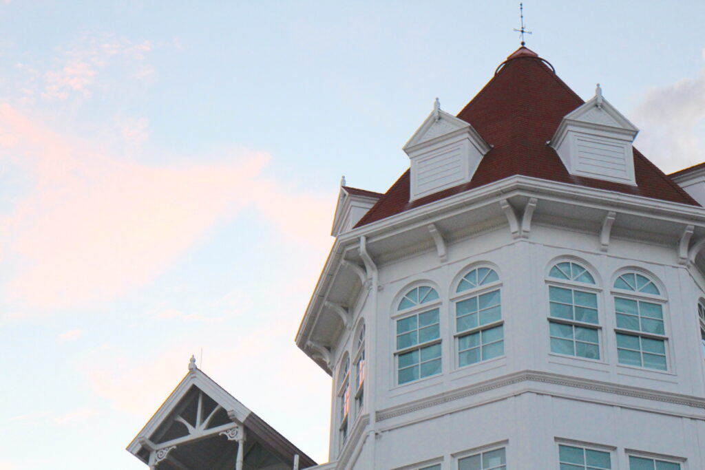 a pastel sunset sits next to a closeup of the Grand Floridian lobby white building and red roof