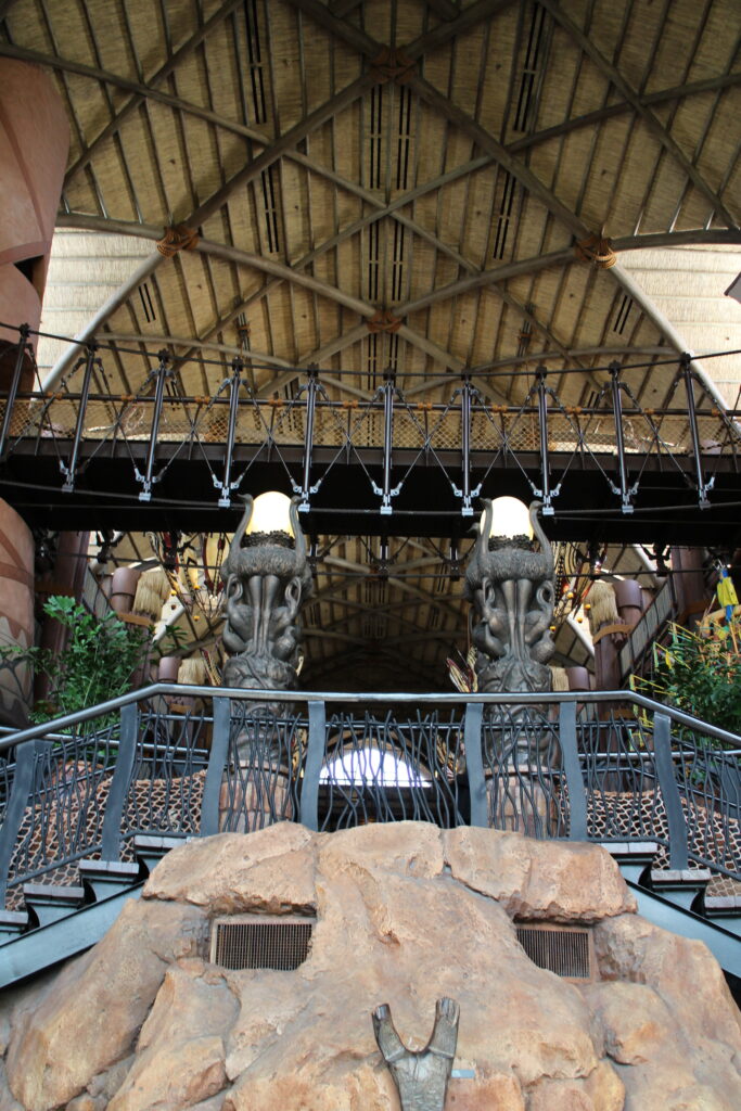 Animal Kingdom Lodge lobby interior with rock work, a double staircase, Ostrich sculptures and a brown, intricate rounded ceiling