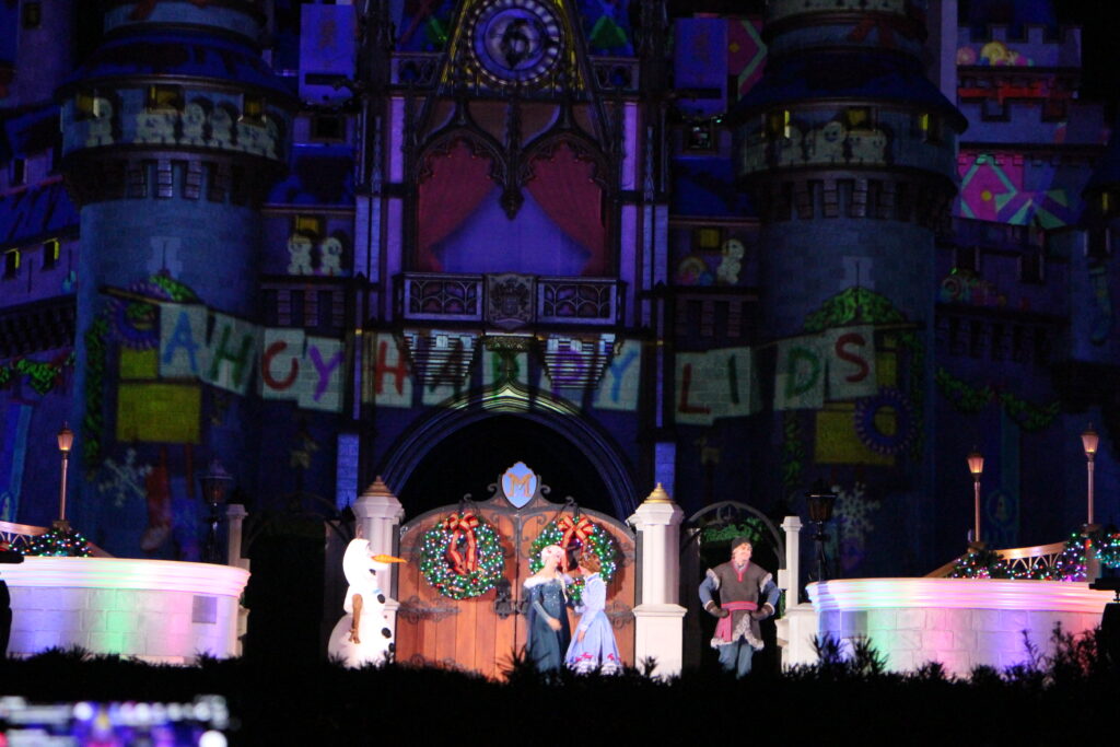 Olaf, Elsa, Anna and Kristoff on the castle stage at Magic Kingdom