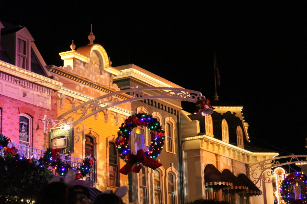 Main Street U.S.A. at Magic Kingdom decorated for Christmas with lighted wreaths and garlands hanging