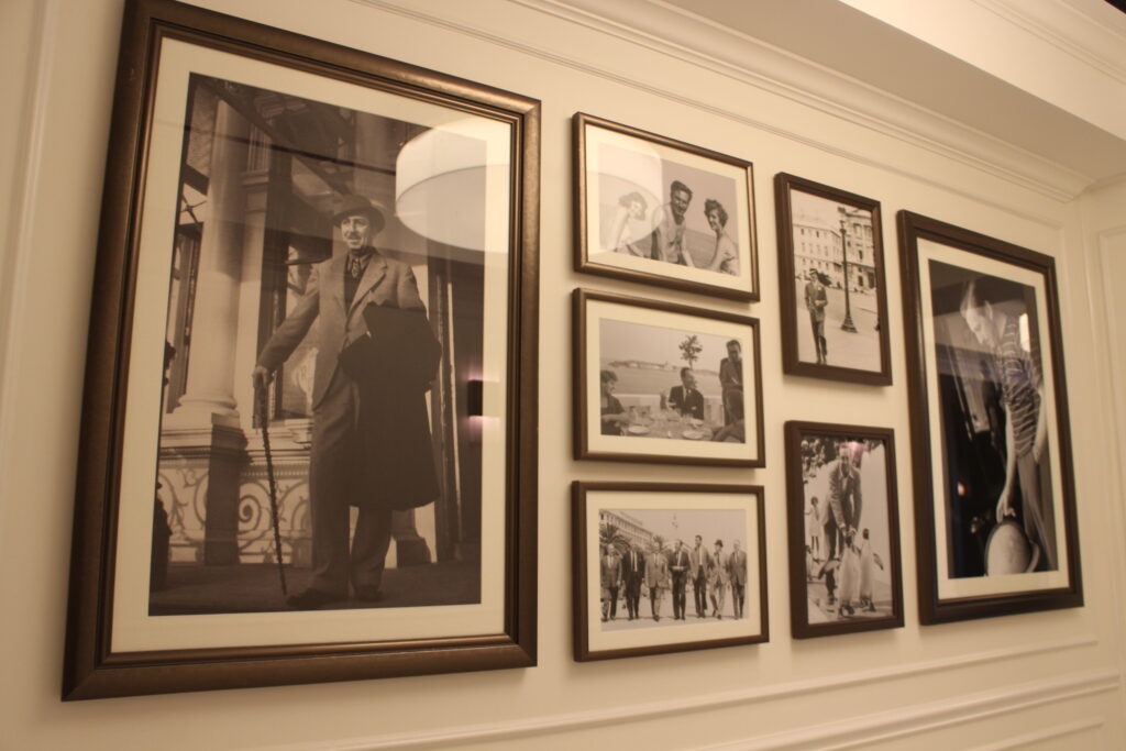 a gallery wall of black and white photos of Walt Disney's travels