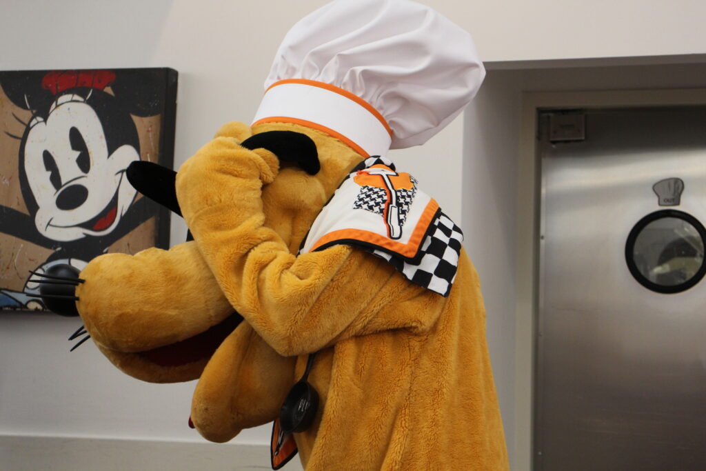 the character pluto covers his eyes with a chef hat on