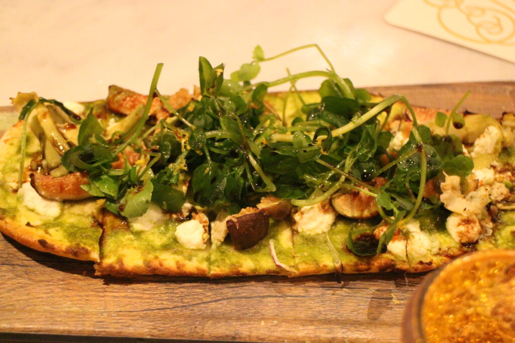 A seasonal flatbread from Enchanted Rose at the Grand Floridian topped with cheese and greens.