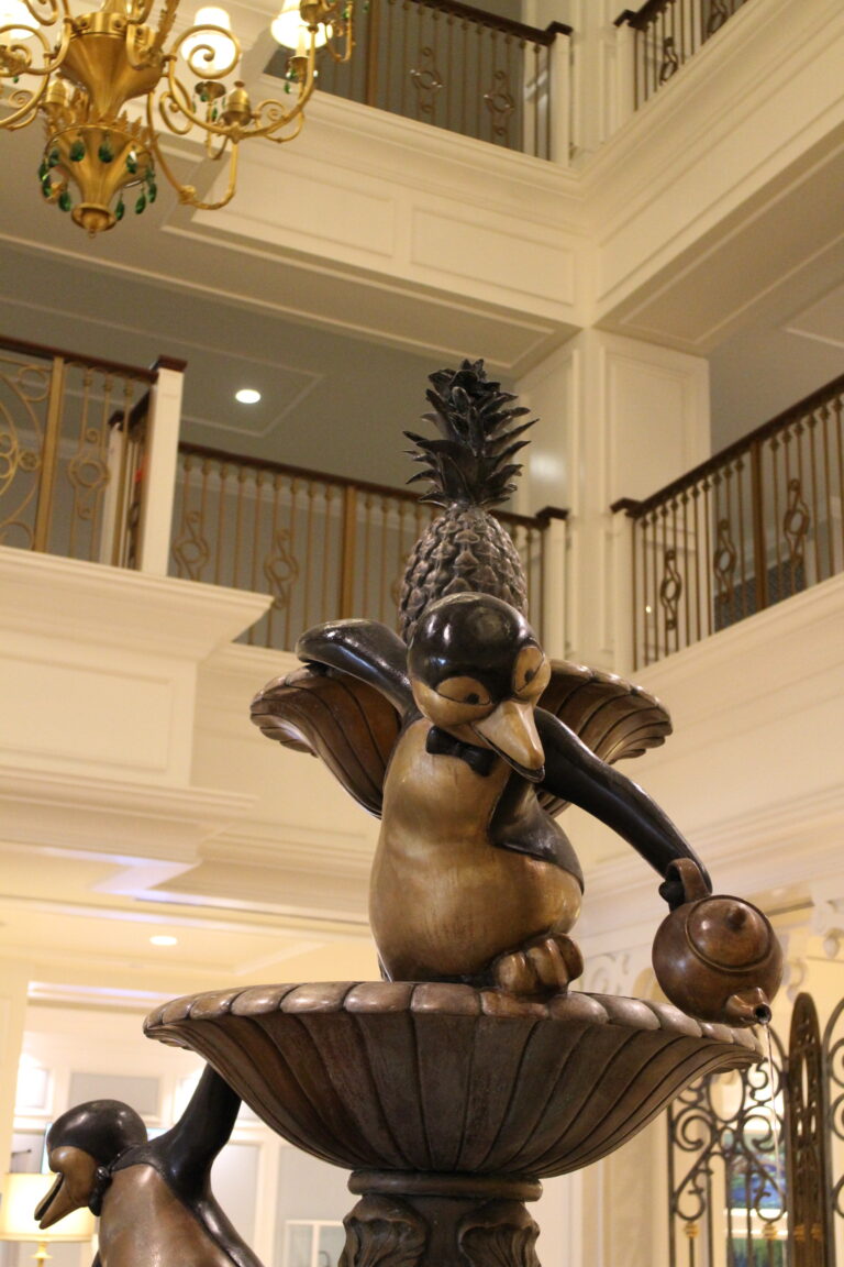 a bronze fountain top with a penguin from Mary Poppins pouring tea out