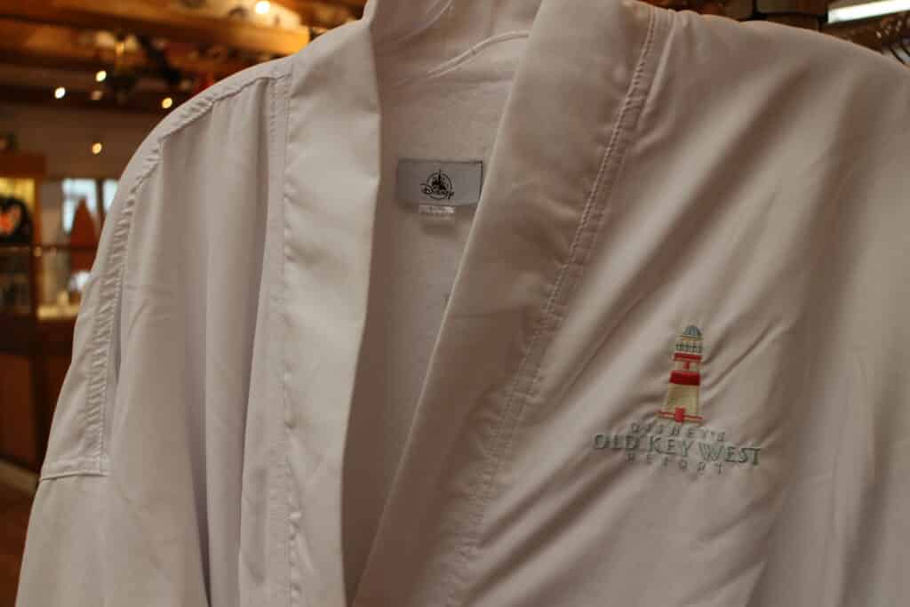 A white bathrobe, that has Disney's Old Key West Resort and a little lighthouse embroidered on the top left, in the resort's gift shop.