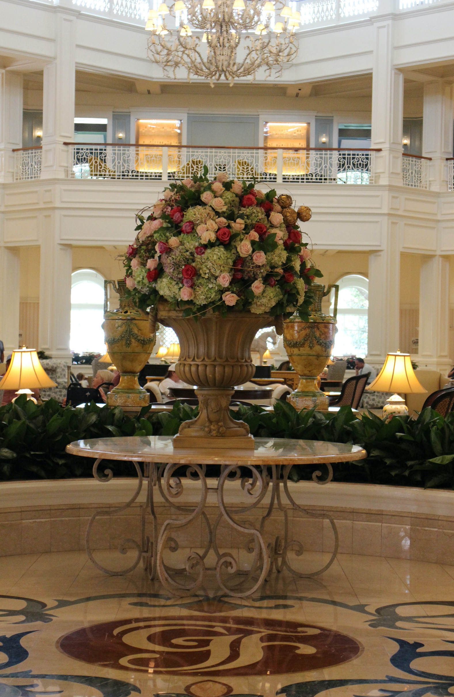 A large vase of roses and hydrangeas sits on a table at the entrance of the Grand Floridian lobby.