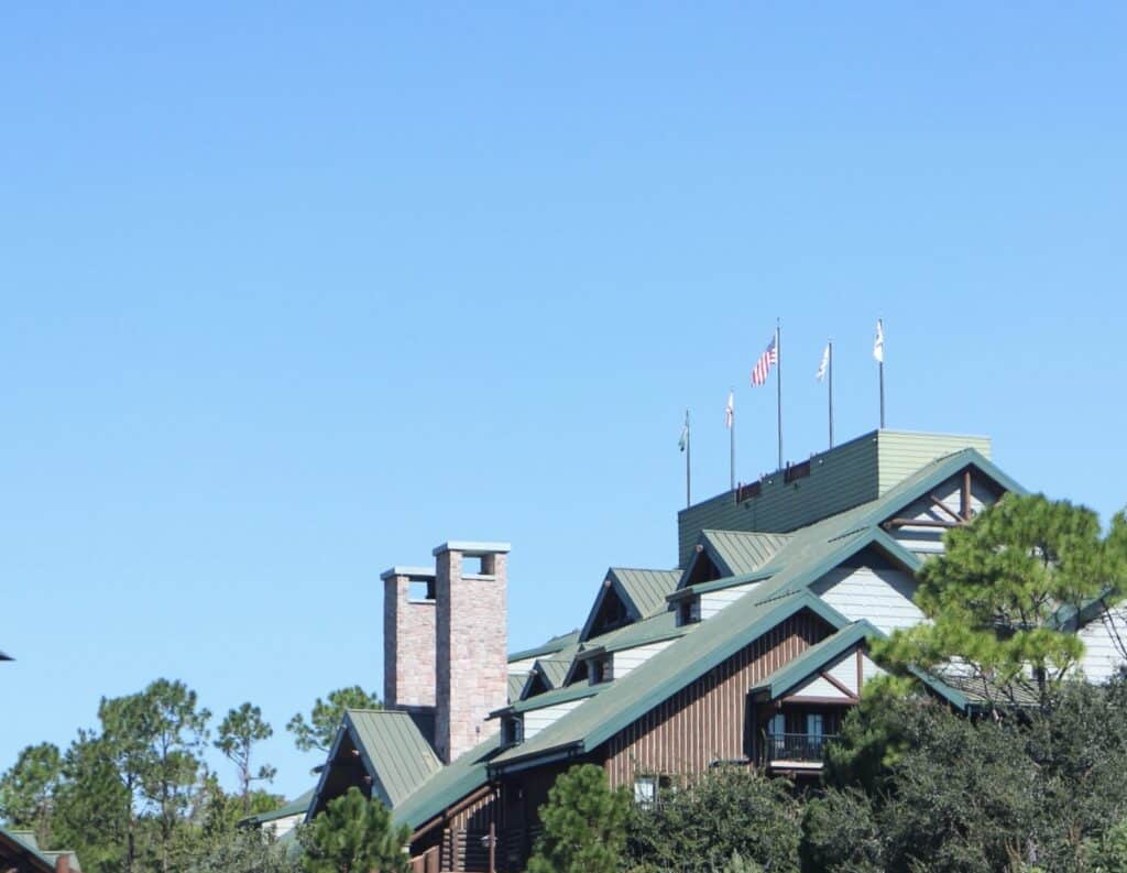 A blue sky and the tops of Wilderness Lodge with a green roof and brown chimneys.