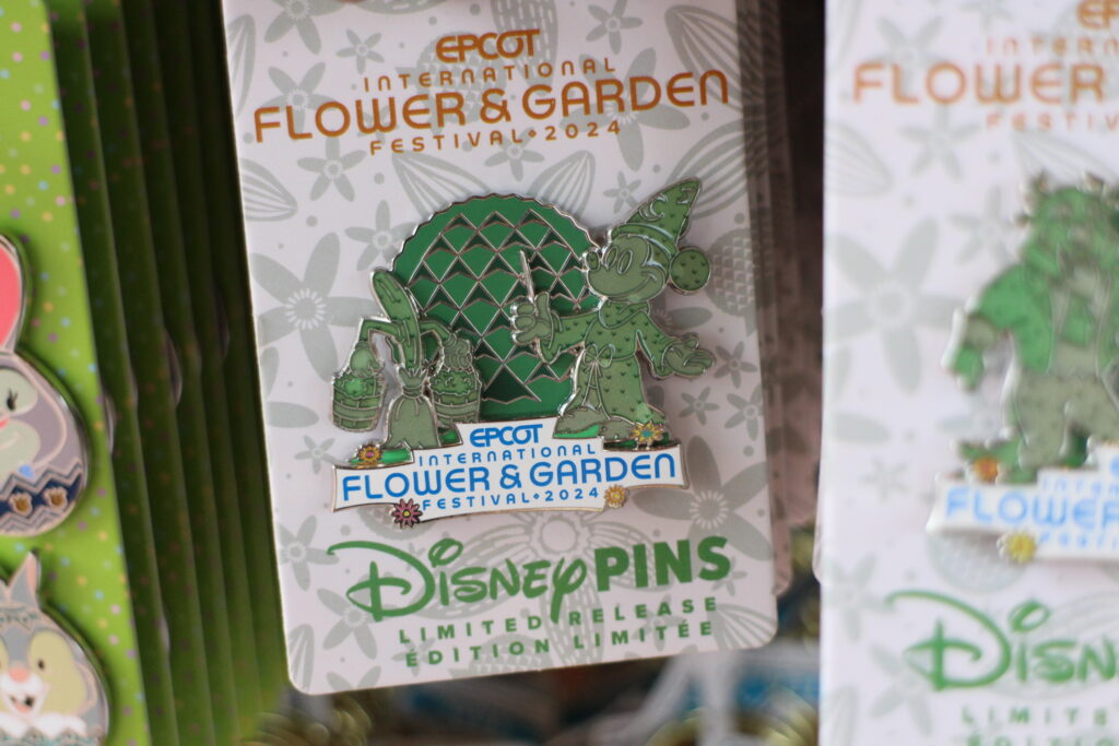 An Epcot flower and garden festival themed pin with Spaceship Earth and Mickey Mouse in his Sorcerer Mickey attire appearing as topiaries.
