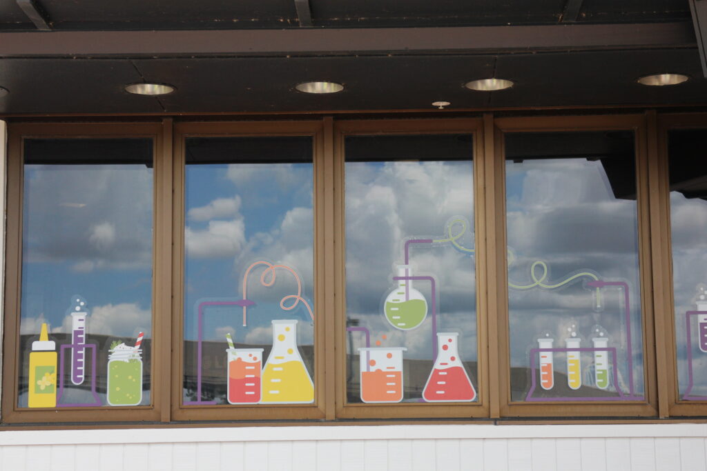 A science themed food and wine venue with windows decorated with beakers.