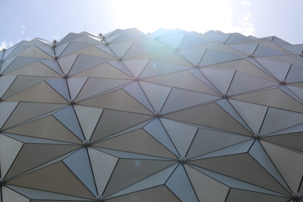 The sun shines colorfully over the geodesic sphere Spaceship Earth attraction.