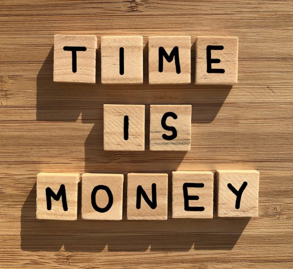 Time is Money in 3D wooden alphabet letters isolated on a bamboo wood background
